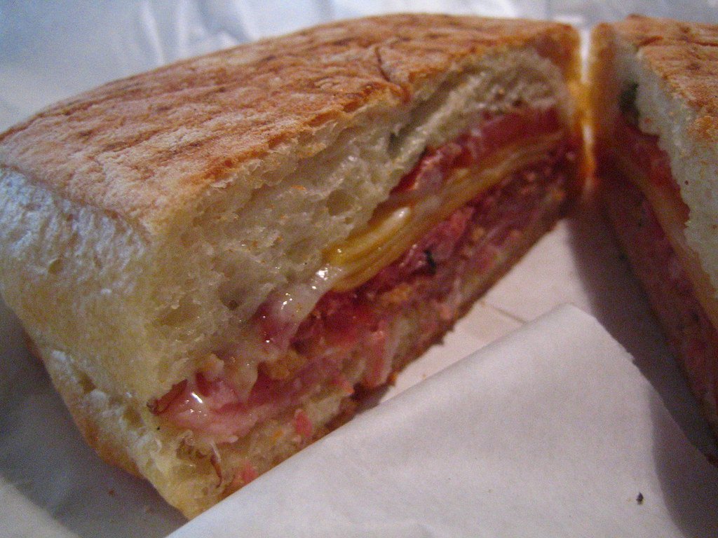 Panino cortado, relleno de jamón y queso